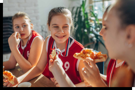 A group of kids eating pizza from Mealz